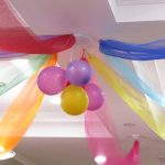 Balloons and decorative fabric streaming from a white ceiling