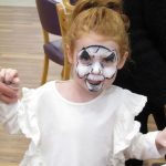 A young child poses with skeleton face paint